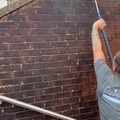 Steam cleaning a brick wall