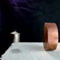 When the magnet goes in the direction of the copper cylinder currents are induced creating a magnetic field against the movement until it is stopped
