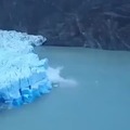 Un iceberg qui chavire révèle une couleur bleu profond en dessous.